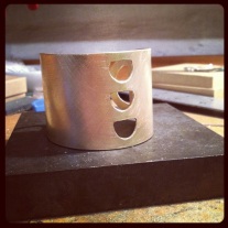 Brass cuff in production.